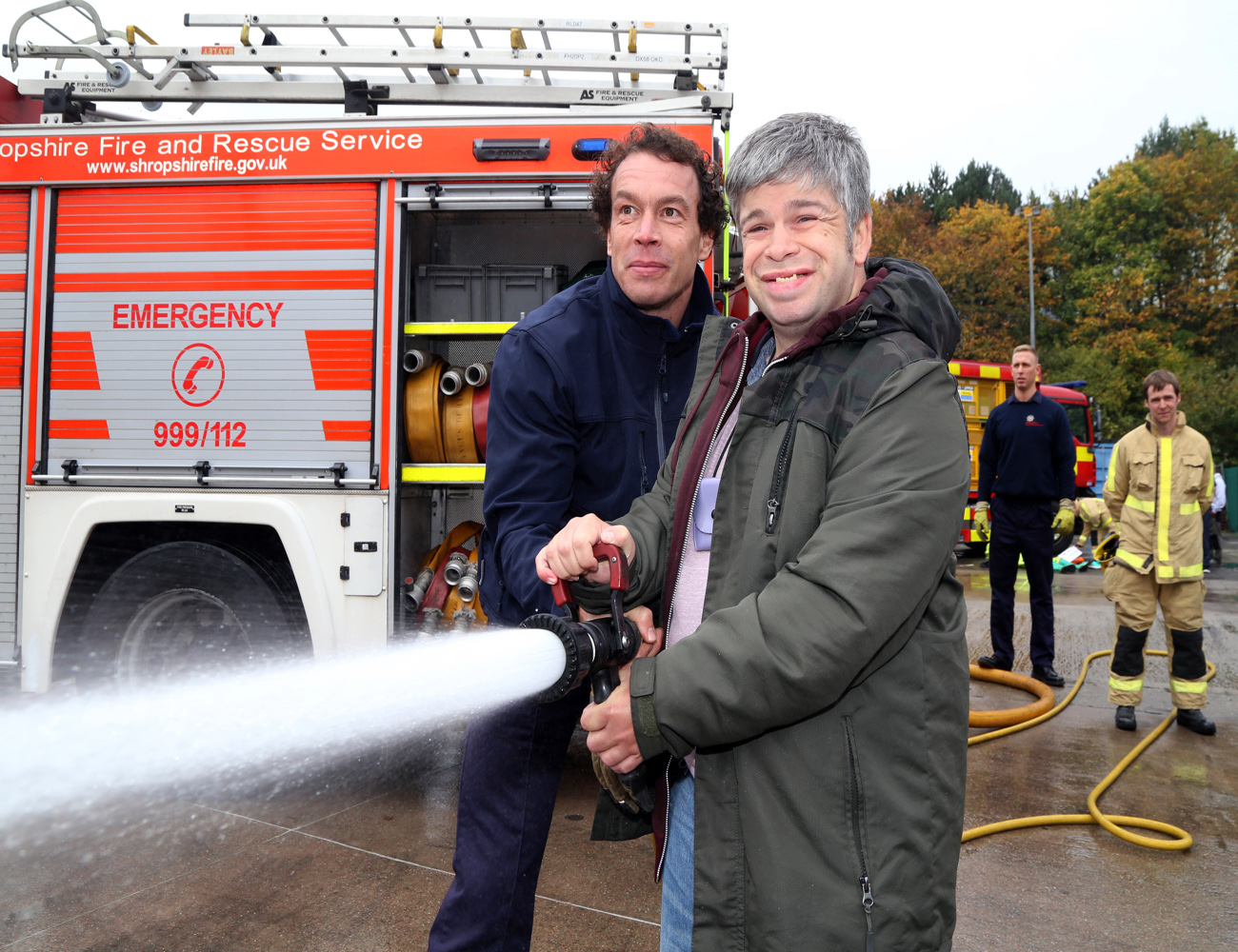 Firefighter Martin Poole shows Martin McCusker how to put out fires.