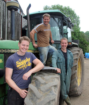 Three brothers pictured on the farm with a tractor