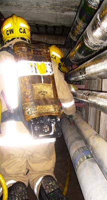 Firefighters with breathing apparatus working in a service tunnel
