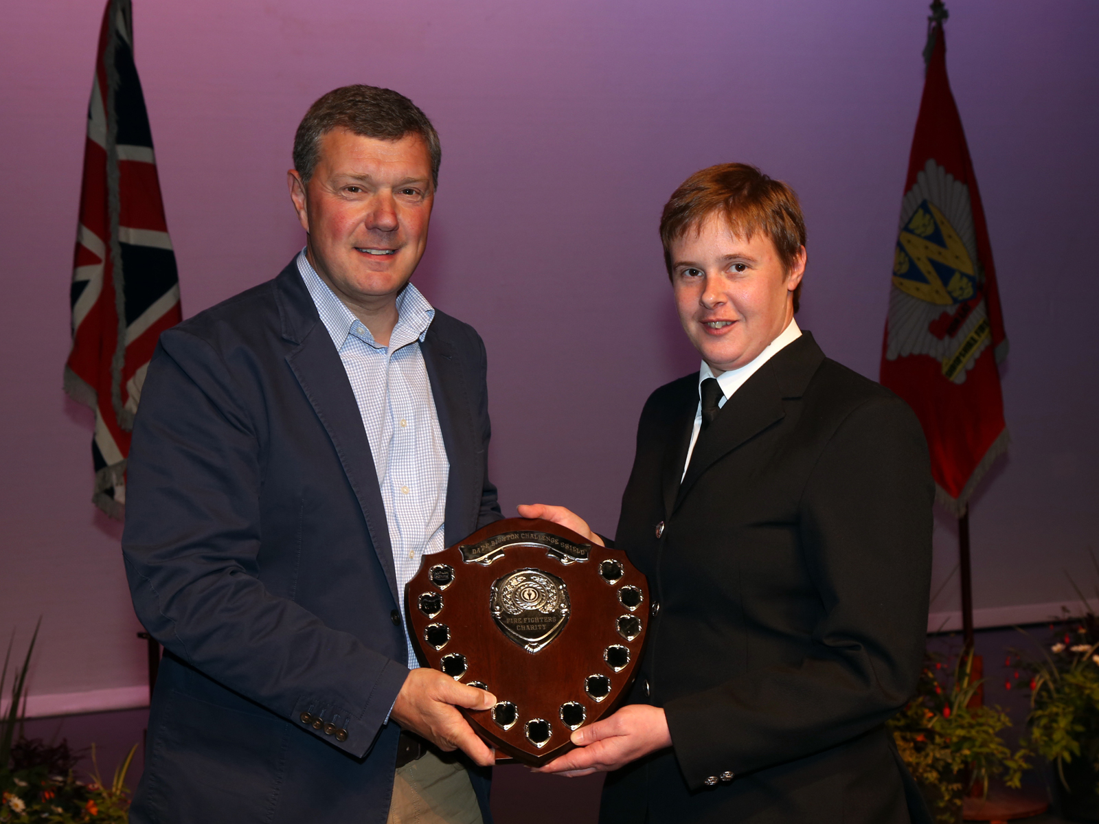 On behalf of Market Drayton Fire Station, firefighter Sally Eynon collects the Dave Bishton Charity Shield for raising £2,278 for the Fire Fighters Charity.