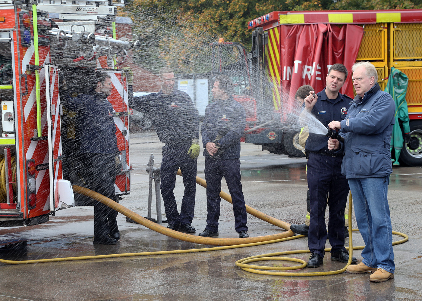 Crew Manager Simon Morris shows a visitor how to operate a fire hose.