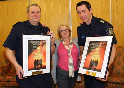 Firefighters pose with care home manager and awards