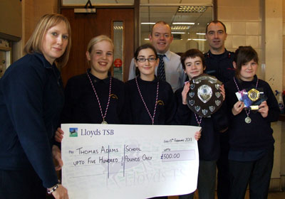 Pupils and Fire Officers pose with large cheque