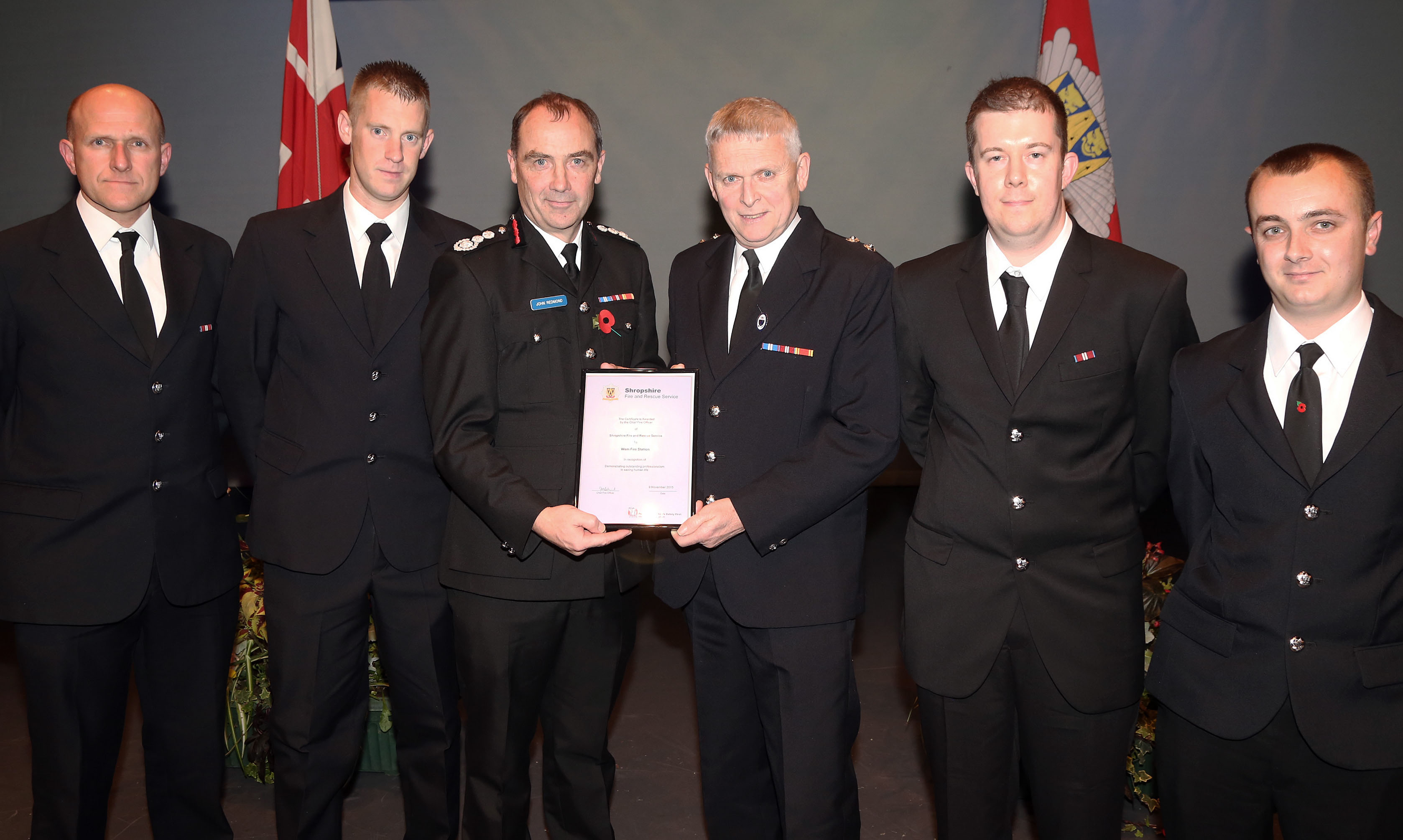 Watch Manager Phil Smith receives the award from Chief Fire Officer John Redmond on behalf of Wem’s fire crew for saving a life. Left to right, John Green, Gary France, John Redmond, Phil Smith, Leon Turner and Darren Jones.  Vic Young (not pictured) was also involved in the rescue.