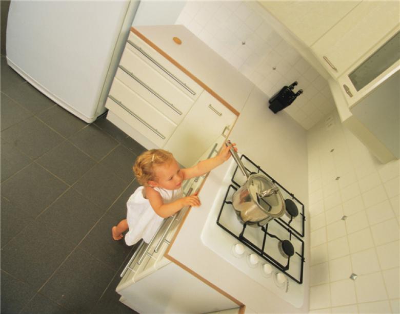 Girl stretches to reach cooker hob