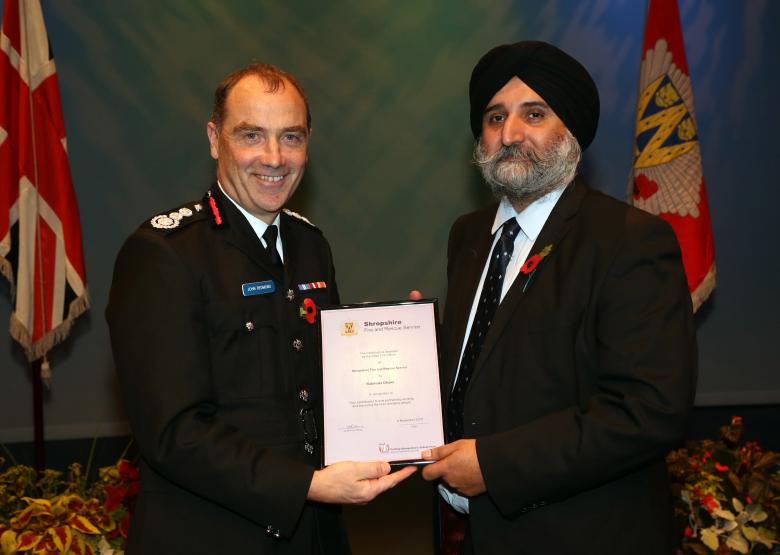 Rabinder Dhami receives his award from Chief Fire Officer John Redmond