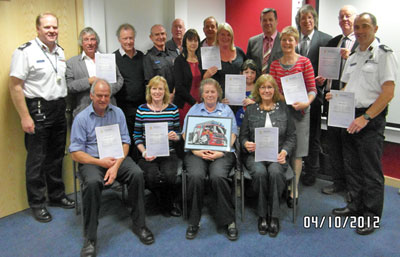 Recipients pose with their certificates in an office room