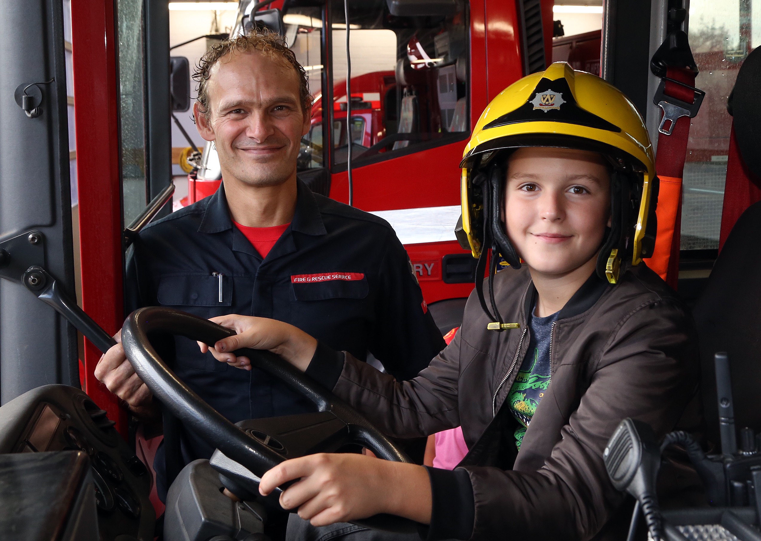 Aboard a fire engine with firefighter  Jon Robinson is Zhenya Shatilo (age 12).