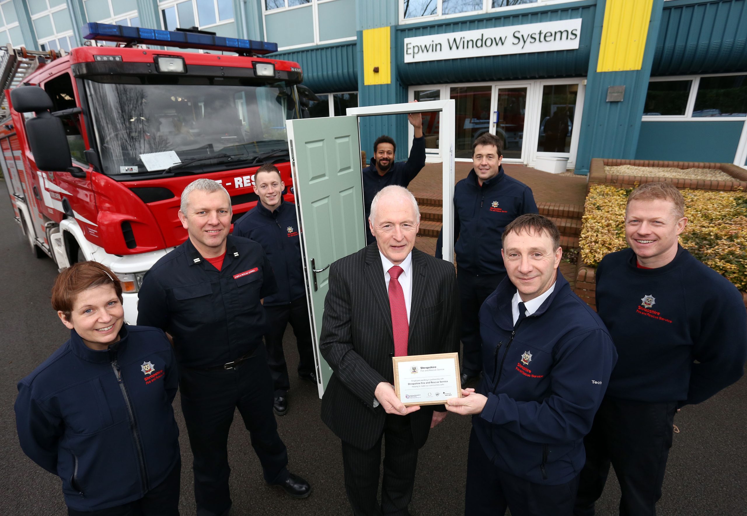 Area Manager John Harrison presents a plaque to Sales Director Paul Lindsay to mark their contribution to Shropshire firefighter training with Green Watch. L to r: firefighters Beverley Morris, Crew Manager Ian Pugh, Joe Thompson, Lee Guinea, Adam Tempest and Mitch Thorne.